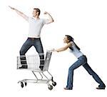 Woman pushing shopping cart with boyfriend inside