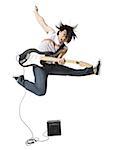 Man playing electric guitar with amp leaping