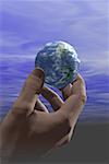 Low angle view of a globe in a person's hand