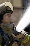 Close-up of a firefighter spraying water from a hose