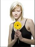 Close-up of a young woman looking at a flower