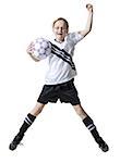 Portrait d'une jeune fille sautant avec un ballon de soccer