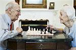 Couple de personnes âgées jouant aux échecs