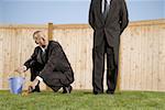 Low angle view of a businessman crouching with another businessman standing beside him