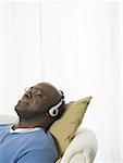 Close-up of a senior man wearing headphones and listening to music