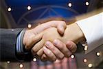 Close-up of a businessman and a businesswoman shaking hands