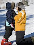 Woman with young girl in ski boots outdoors