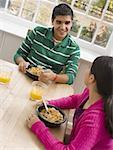 High angle view of brother and sister sitting at a breakfast table