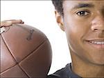 Close-up of a teenage boy holding a football