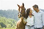 Un homme et une femme debout avec un cheval