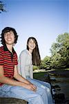 Teenage couple sitting along a stream