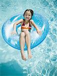 Jeune fille flottant sur la bouée de sauvetage en piscine