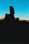 Silhouette of a person climbing a rock formation
