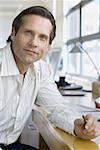 Portrait of a businessman resting his hand on the table