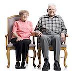 Portrait d'un couple supérieur, assis sur un fauteuil