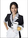 Porträt der Kellnerin hält eine Platte mit einer Kaffeetasse und Kekse