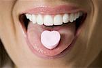 Close-up of candy on a young woman's tongue