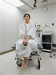 Low angle view of a young woman sitting on an examination table