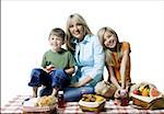 Portrait of a mother and her two children having a picnic