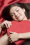 Grand angle Découvre d'une jeune femme de dormir avec un cœur en forme de boîte