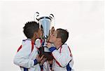 Soccer Players Kissing Trophy