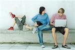 Young friends, one using laptop