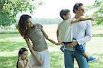 Family standing outdoors on lawn on a sunny day