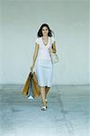 Woman walking with shopping bags, full length