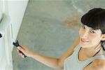 Woman painting with paint roller, high angle view