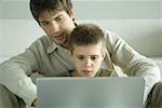 Father and son using laptop together