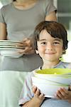 Mother and son carrying dishes together