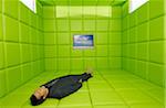 Man Lying on Back in Green Padded Room with Television