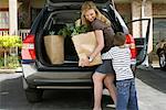 Mother and Son Removing Groceries from Car