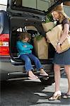 Mother with Daughter, Removing Groceries from Car