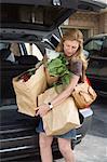 Woman Removing Groceries from Car