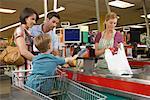 Famille au caissier dans une épicerie