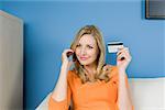 Woman using credit card and cell phone