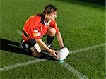 Rugby player placing ball