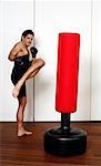 Young man kicking a punching bag