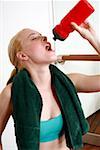 Young woman drinking water during an exercise session