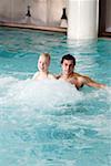 Jeune couple de nager dans la piscine thermale