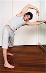 Young man stretching in gym