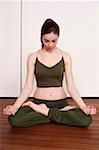 Young woman in a fitness class meditating