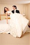 Groom holding bride in his arms in hotel room