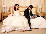 Bride waiting for groom to get off his laptop