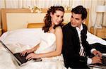 Bride and groom on laptops