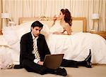 Bride drinking and groom on laptop