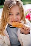 Jeune fille mangeant un beignet