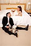 Braut und Bräutigam Toasten im Hotelzimmer
