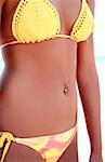 Midriff of young woman in bikini